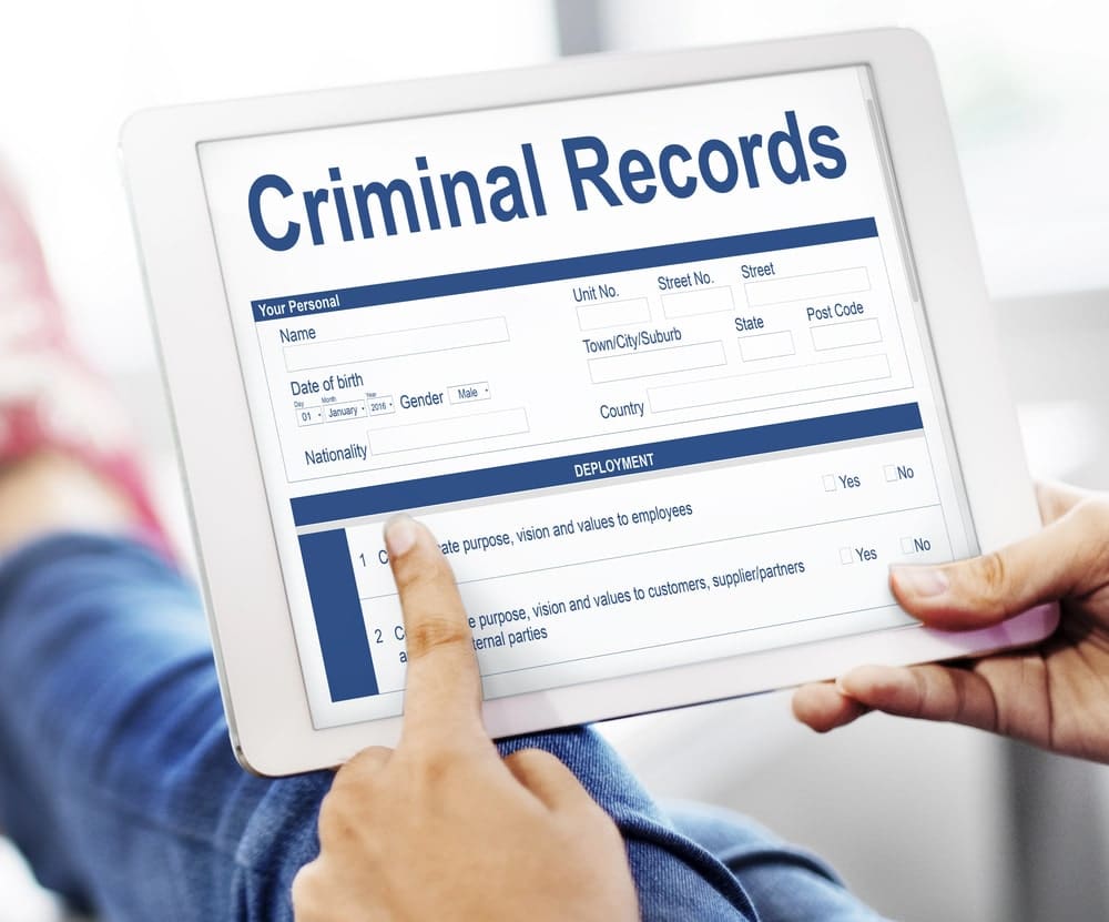 Person reviewing criminal records on tablet.