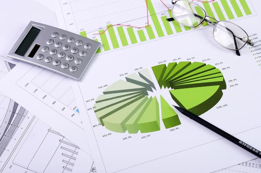 Image shows financial charts, calculator, and reports used for asset searches used in business due diligence review