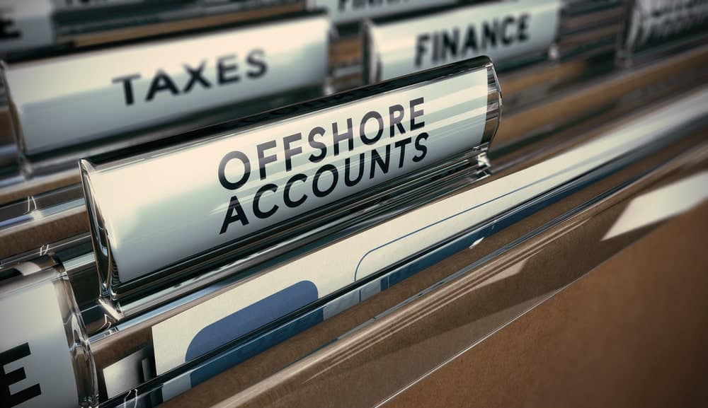 Image is of organized financial filing drawers labeled offshore accounts and taxes, concept of asset searches reviewing records to trace asset ownership and movement