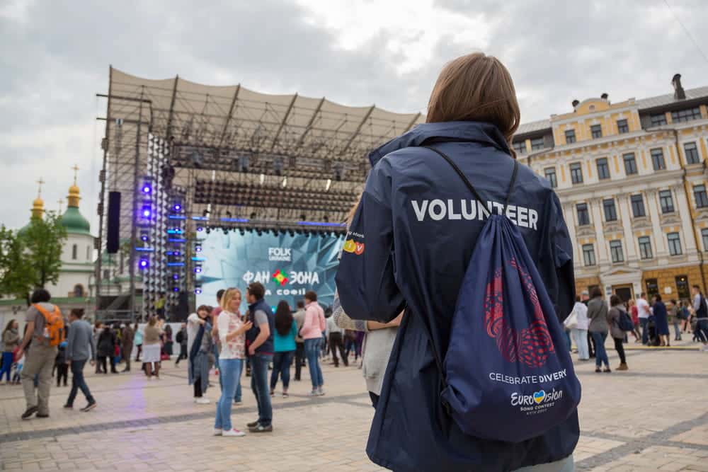Image is of a volunteer wearing an identification jacket at a public event, highlighting real world application of volunteer screening rules for safety.