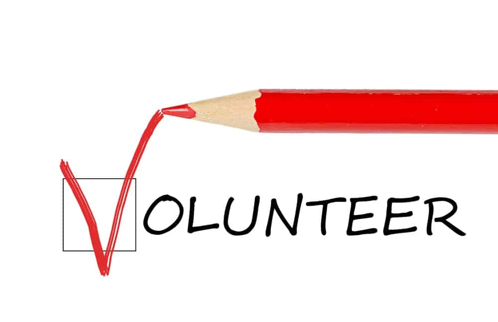 Image is of a red pencil marking a checkbox next to the word volunteer, representing volunteer screening rules for organizations reviewing eligibility.