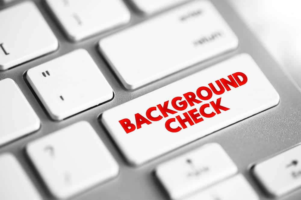 Image is of a keyboard button labeled background check, representing criminal record screening and employment in WA