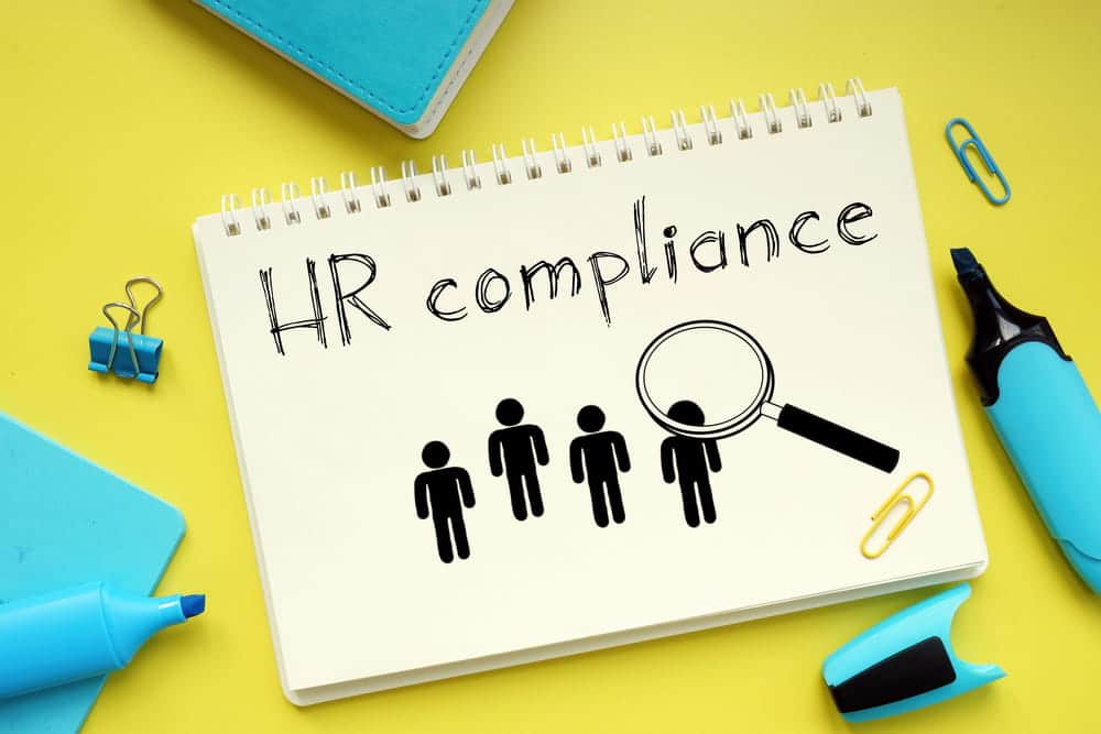 Image is of an HR compliance notebook with employee icons and magnifying glass, showing hiring review practices affecting employment in WA
