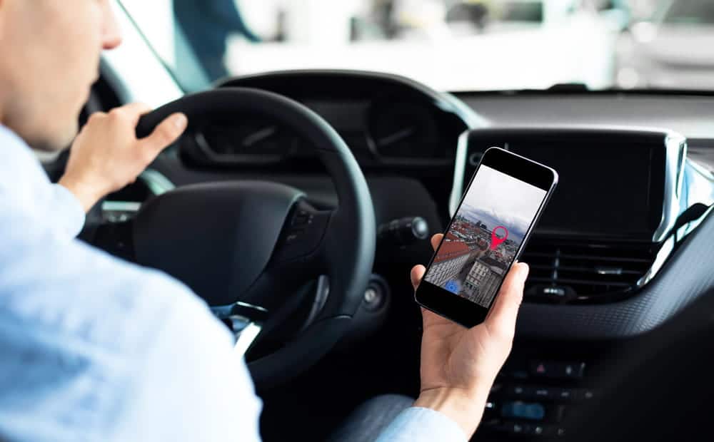 Image is of a driver using a mobile phone while driving, example of a traffic violation relevant to WA backgrounds